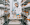 A man wearing a lab coat and gloves working in a laboratory with lots of specimen jars