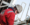 An image of a man in a red boiler suit wearing a hard hat working outside on machinery